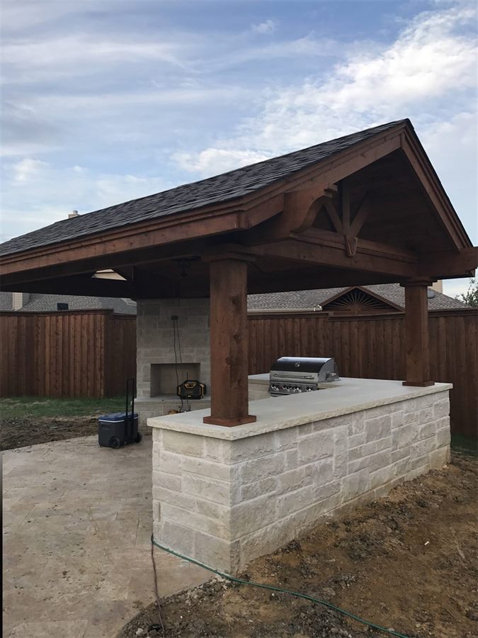 Covered pergola with a stone outdoor kitchen